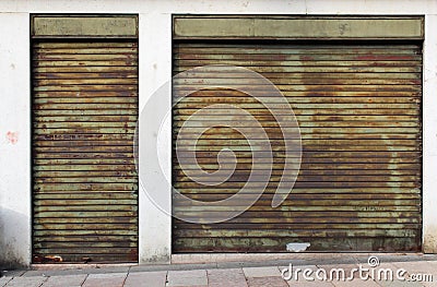 Closed green metal rolling shutters on an old building Stock Photo