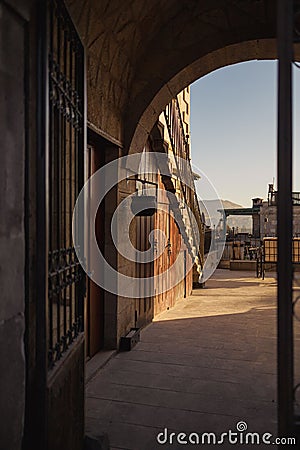 Old cobbled street in Uchisar leading to medieval buildings in warm afternoon sunlight, Cappadocia, Turkey Stock Photo