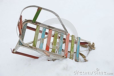 Old colored sledges in the snowdrift of white snow on the street Stock Photo