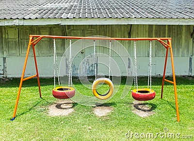 Old Colorful Empty Chain Swings made from Vehicle Wheels on Kids Playground in Thailand Stock Photo