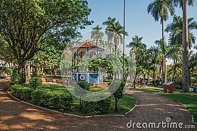 Old colorful gazebo in the middle of square and verdant garden full of trees, at sunset in SÃ£o Manuel. Stock Photo
