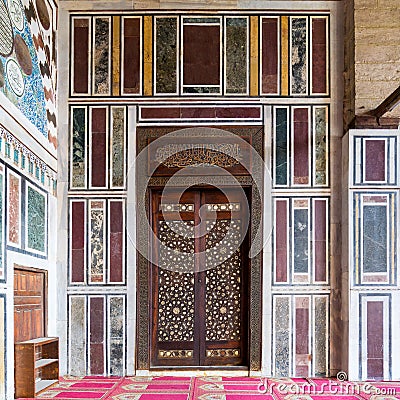 Old colorful marble wall with wooden door decorated with arabesque ornaments, Cairo, Egypt Stock Photo