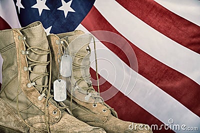 Old combat boots and dog tags with American flag Stock Photo