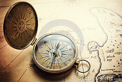 Old compass on vintage map. Adventure stories background. Stock Photo