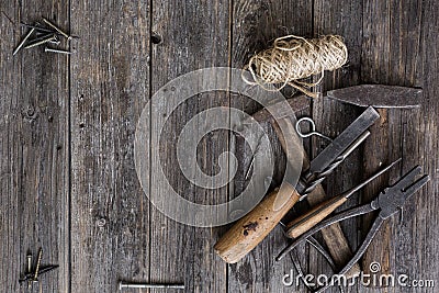 Old construction tools hammer, pliers, screwdriver, chisel lie on aged wooden boards of dark color with expressive texture Stock Photo