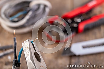 Old copper electric wire and combination pliers. Electrical installation repair Stock Photo