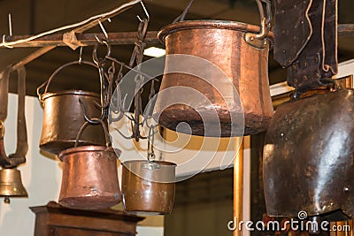 Old copper pots hanged on iron hooks Stock Photo