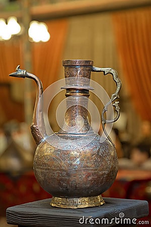 Old copper water ewer over yellow background Editorial Stock Photo