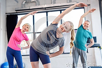 Old couple and girl exercising in fitness class for kids and senior people Stock Photo