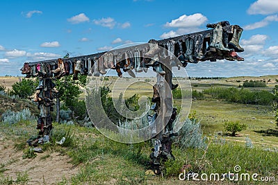 Old cowboy boots hanging on a post in Great Sandhills in Saskatchewan, Canada Stock Photo