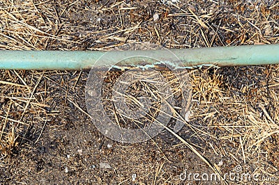 Old crack blue pipe on the ground Stock Photo