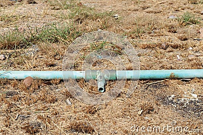 Old crack blue pipe on the ground Stock Photo