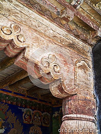 Old, cracked wooden columns of the ancient Buddhist temple, decorated with beautiful antique ornaments Stock Photo