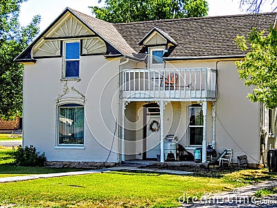 Old, cracking, white house with a balcony Stock Photo