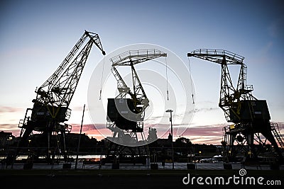 Old cranes in Szczecin by sunset. Szczecin, Poland. Stock Photo