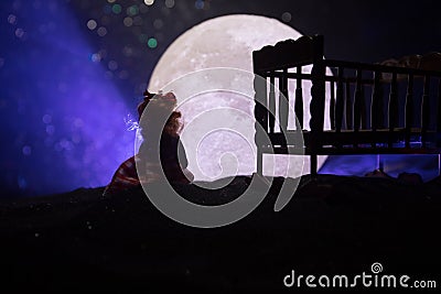 Old creepy eerie wooden baby crib in dark toned foggy background. Horror concept. Scary baby and bed silhouette in dark. Halloween Stock Photo