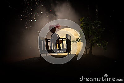 Old creepy eerie wooden baby crib in dark toned foggy background. Horror concept. Scary baby and bed silhouette in dark. Halloween Stock Photo