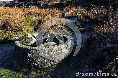 Old cylindrical gritstone object on the slopes of Burbage Edge Stock Photo