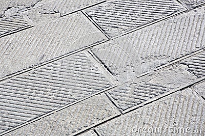 Old and damaged italian paving made with chiseled grey sandstone blocks in a pedestrian zone Stock Photo