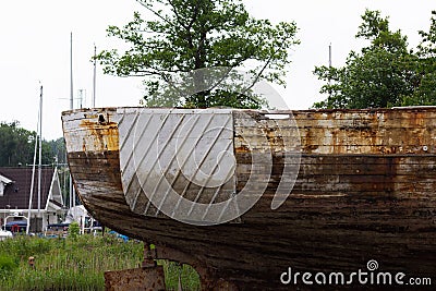 The old and damaged rusty wooden boat Stock Photo