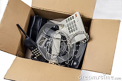 Old desk phones in a cardboard box. Stock Photo