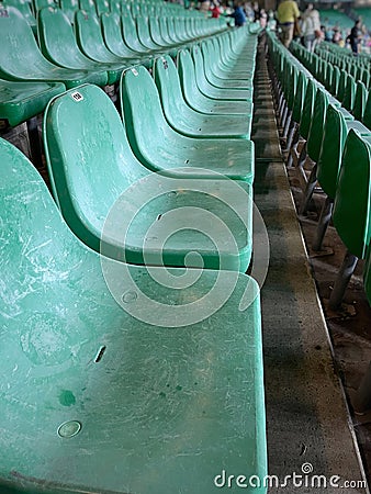 Old, deteriorated, empty green seats in a sports stadium Stock Photo