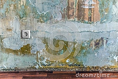 Old dilapidated wall with layers of paint, plaster, pieces of torn wallpaper Stock Photo