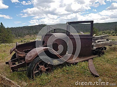 Old dilapidated 1920& x27;s roadster in front of a mining cabin Stock Photo