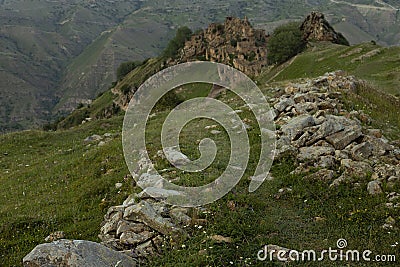 Old dirt road with stones to ancient ruin of stone impregnable city on peak of mountain in highlands in Dagestan in blur. Stock Photo
