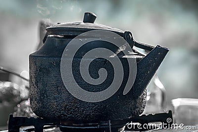 An old, dirty camp teapot sitting Stock Photo