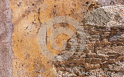 Old, distressed stone wall, building facade. Painted and faded, orange color masonry, texture background Stock Photo