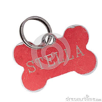 Old dog name tag in shape of bone, red, with name Stella. Memento to remember deceased pet, isolated on white Stock Photo