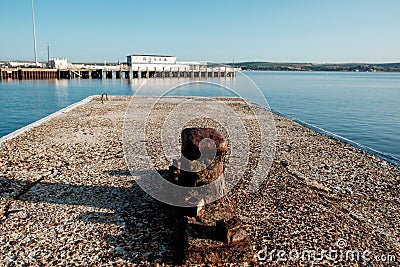 Old dock cleat in Weymouth harbor in the morning. Pier in the horizon Stock Photo
