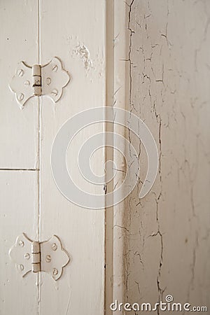 Old door hinges and cracking white paint on an antique furniture Stock Photo