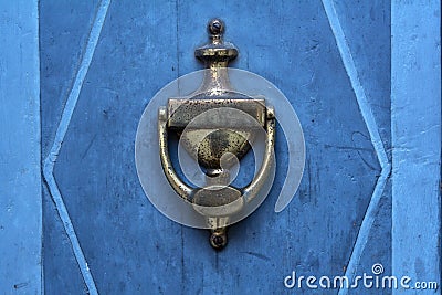 Old doorknocker from brass on a blue door Stock Photo