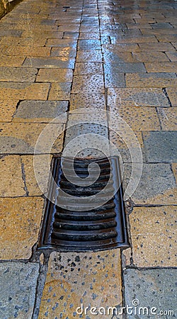 Old medieval drain and stone covered street Stock Photo