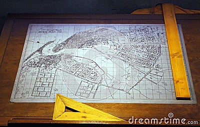 Old drawing of the city of Dubai in the 60s placed on an architectâ€™s table with wooden geometry tools. Editorial Stock Photo