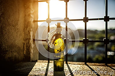 Old, dusty bottle of wine on the windowsill, sunlight. Stock Photo