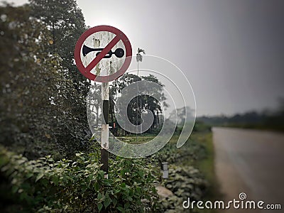 Old dusty no horn sign at the highway Stock Photo
