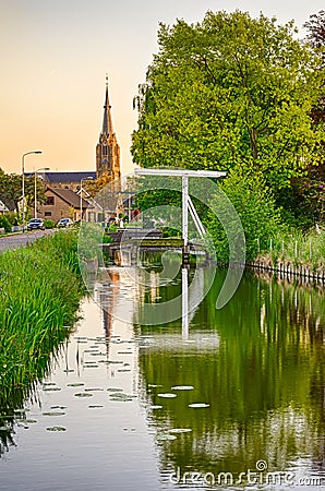 Old Dutch bridge, canal and church Stock Photo