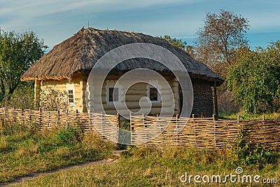 Old rural house with wattle fence in village Stock Photo