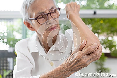 Old Elderly experiencing elbow pain,stiffness and swelling,irritation of joint,painful inflammation of tendons in the elbow, Stock Photo