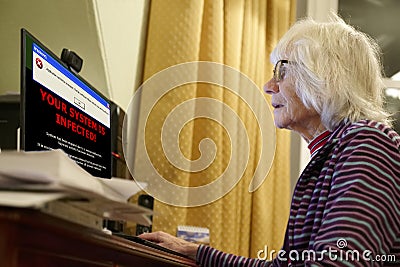 Old elderly senior person with virus warning on computer monitor screen Stock Photo