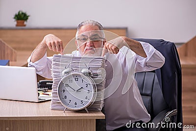 Old male employee in time manegement concept Stock Photo