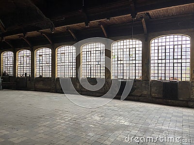 Old emptied school sports hall dramatic natural lighting Interior of an building with windows brick floor Stock Photo