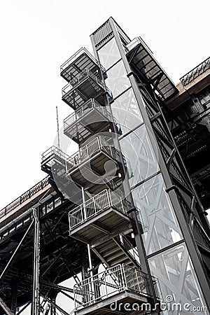 Old external elevator and steel stairway Stock Photo