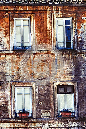 Old facade four windows home. Ancient bricks wall Stock Photo