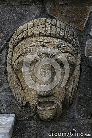 Old face of stone into an antique wall at millazzo city Editorial Stock Photo