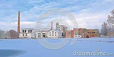 Old factory buildings and chimney along a snow covered park Editorial Stock Photo