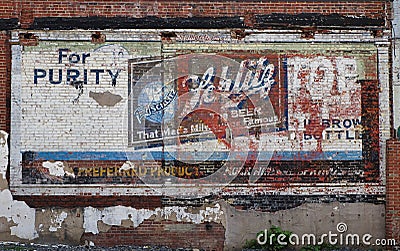 Old faded painted beer advertising billboard in a brick wall Editorial Stock Photo